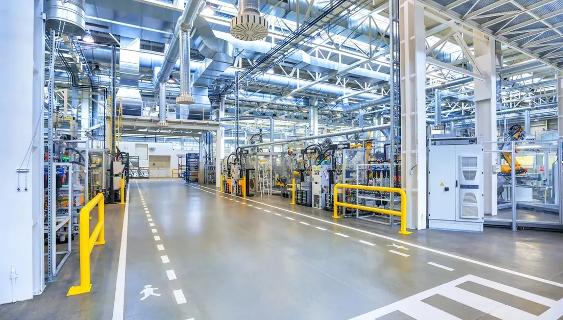 Passagem industrial entre equipamentos, com piso demarcado