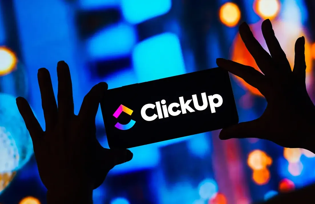 Logotipo do ClickUp exibido em luz sobre fundo escuro